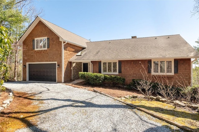 view of front of property with a garage, gravel driveway, and a shingled roof