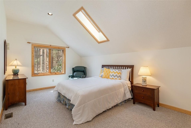 bedroom with visible vents, vaulted ceiling with skylight, baseboards, and carpet floors