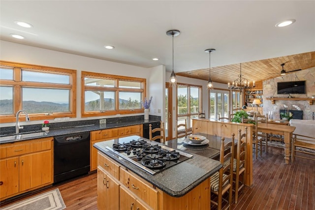 kitchen with light wood-type flooring, black appliances, a sink, open floor plan, and lofted ceiling