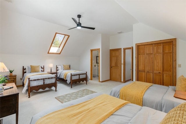 bedroom with visible vents, lofted ceiling with skylight, light colored carpet, a closet, and a ceiling fan