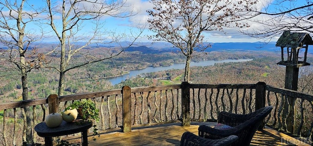 wooden terrace featuring a water and mountain view