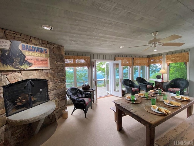 living room with ceiling fan and a fireplace