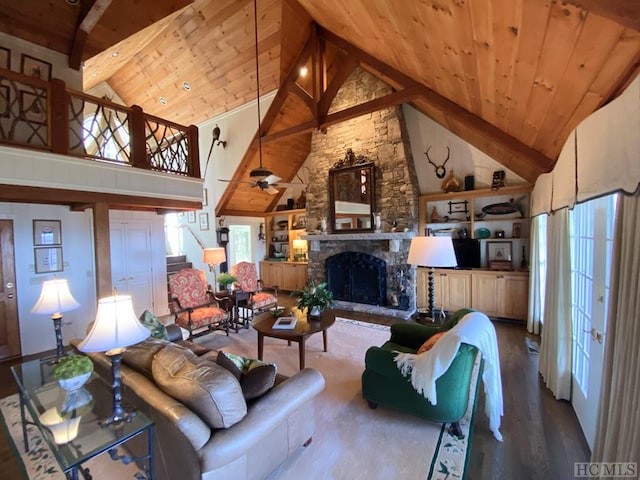 living room featuring wood ceiling, a stone fireplace, and high vaulted ceiling