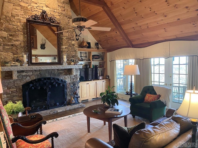 living room featuring ceiling fan, a stone fireplace, wooden ceiling, french doors, and beamed ceiling