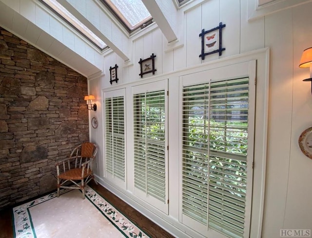 interior space with a wealth of natural light and vaulted ceiling with skylight