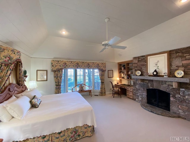 carpeted bedroom featuring ceiling fan, a fireplace, and vaulted ceiling