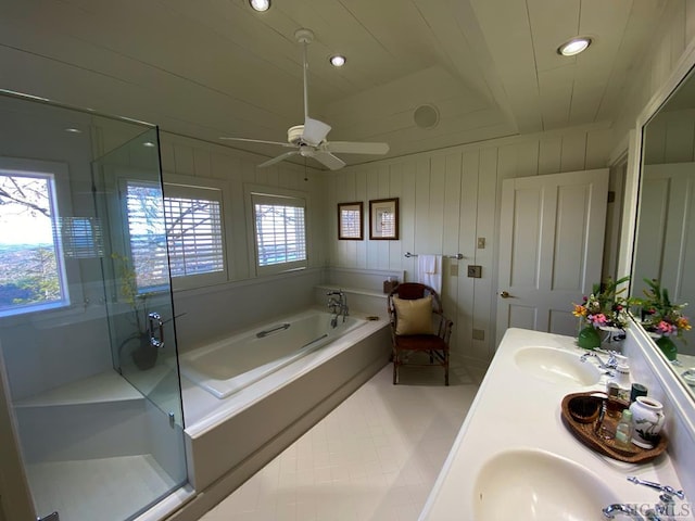 bathroom featuring ceiling fan, wooden walls, vanity, and shower with separate bathtub