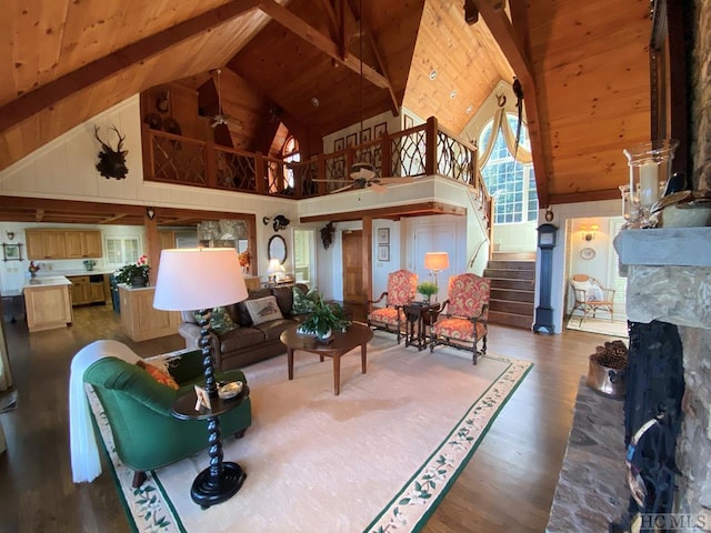 living room featuring beamed ceiling, wood ceiling, high vaulted ceiling, and a fireplace