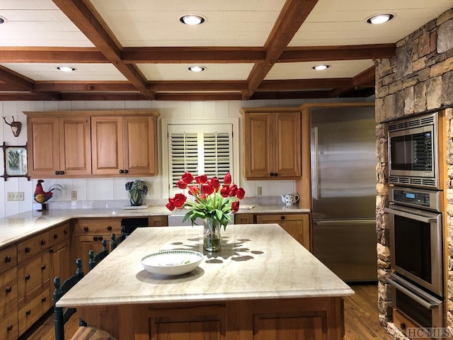 kitchen with built in appliances, coffered ceiling, and a center island