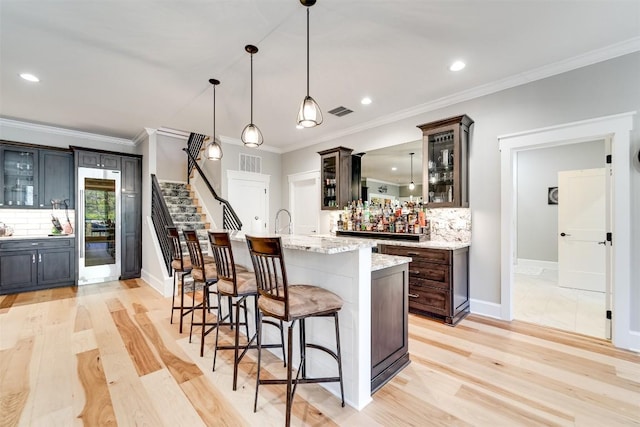 1132 Southshore Dr, Tuckasegee, NC 28783 - kitchen featuring glass insert cabinets, visible vents, light wood-style flooring, and a kitchen breakfast bar