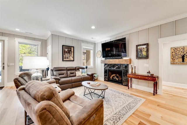 1132 Southshore Dr, Tuckasegee, NC 28783 - living room with a decorative wall, a premium fireplace, wood finished floors, baseboards, and crown molding