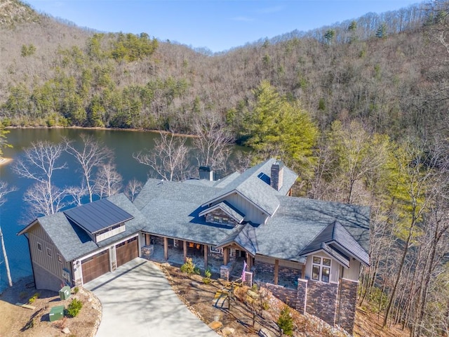 drone / aerial view featuring a water view and a forest view