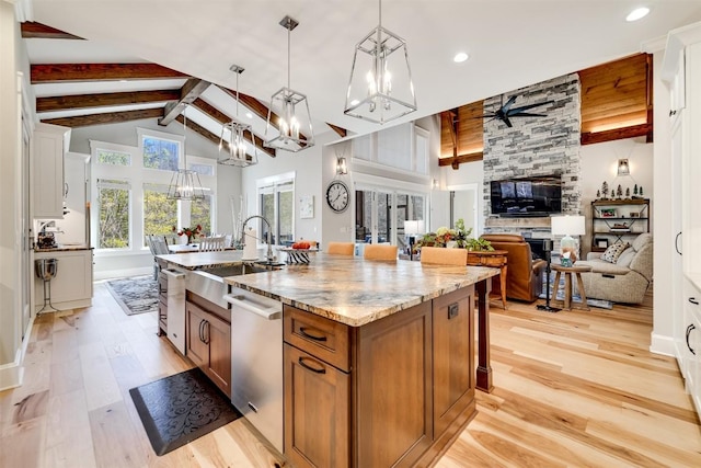 1132 Southshore Dr, Tuckasegee, NC 28783 - kitchen with stainless steel dishwasher, brown cabinets, light wood finished floors, beamed ceiling, and a center island with sink