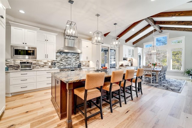 1132 Southshore Dr, Tuckasegee, NC 28783 - kitchen with stainless steel microwave, wall chimney range hood, a large island, decorative backsplash, and beamed ceiling