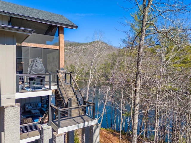 1132 Southshore Dr, Tuckasegee, NC 28783 - view of property exterior featuring a sunroom, roof with shingles, and a wooded view