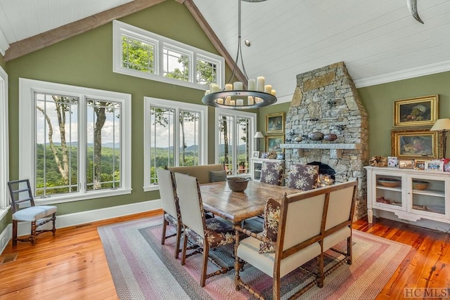 dining space featuring a fireplace, an inviting chandelier, and a healthy amount of sunlight