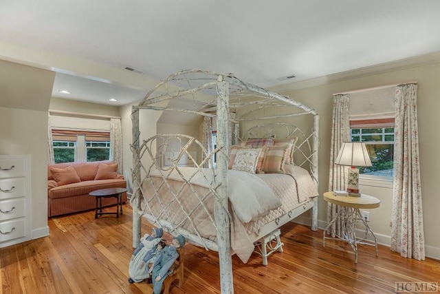 bedroom with hardwood / wood-style flooring and ornamental molding