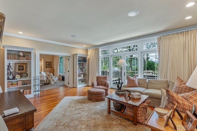 living room featuring crown molding, light wood-type flooring, and french doors