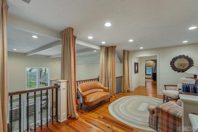 living area featuring light hardwood / wood-style flooring and beamed ceiling