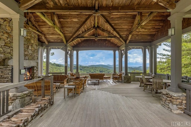 exterior space with a mountain view, a gazebo, and an outdoor stone fireplace