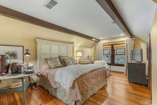 bedroom with light wood-type flooring and lofted ceiling with beams