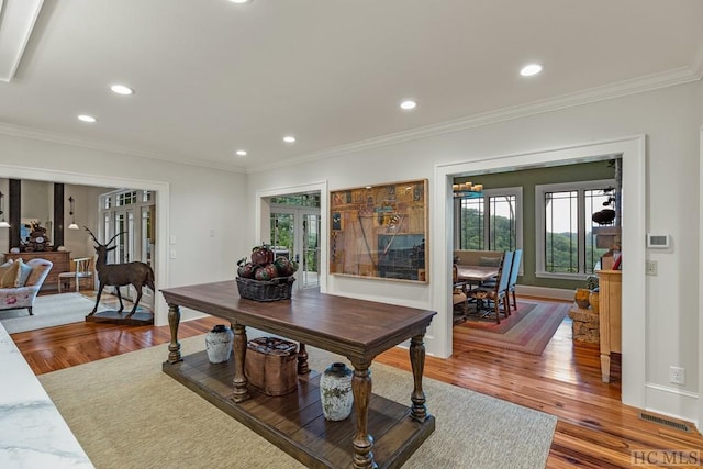 interior space featuring hardwood / wood-style flooring, ornamental molding, and french doors