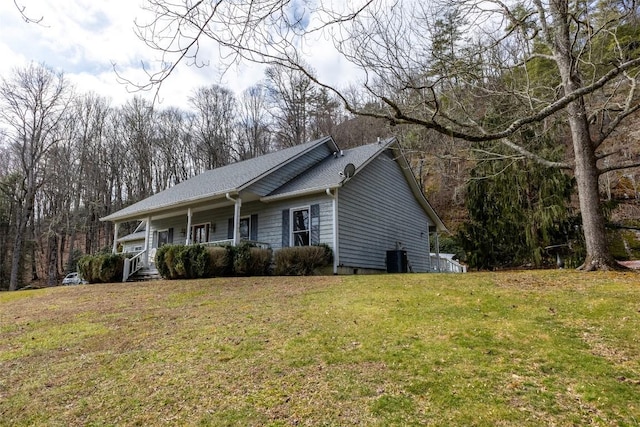 view of property exterior featuring cooling unit, covered porch, and a yard