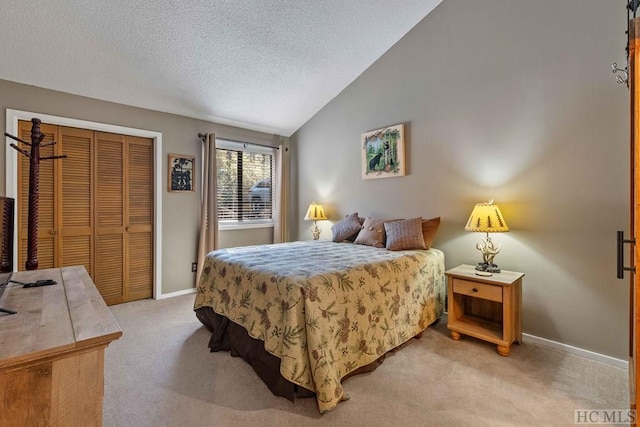 bedroom featuring vaulted ceiling, light colored carpet, a closet, and a textured ceiling