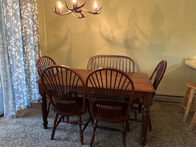 carpeted dining space featuring baseboard heating and a chandelier