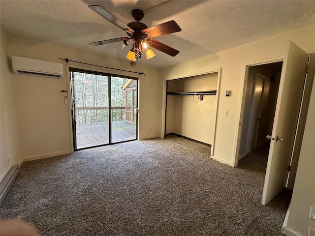 unfurnished bedroom featuring a wall mounted air conditioner, access to exterior, a textured ceiling, and dark colored carpet