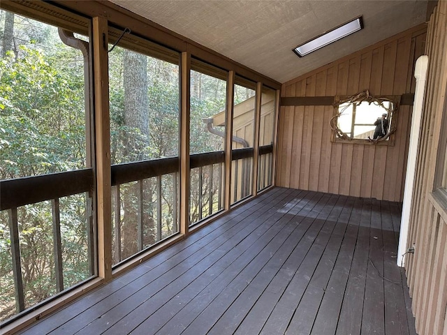 unfurnished sunroom with vaulted ceiling with skylight