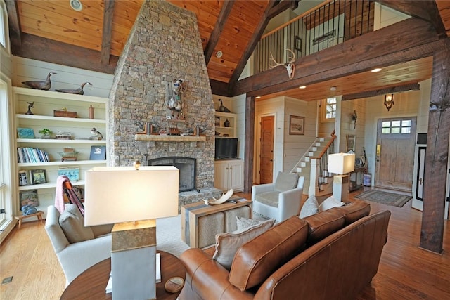 living room featuring wood finished floors, wooden ceiling, stairway, a fireplace, and high vaulted ceiling