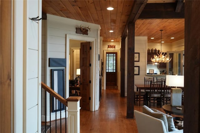 hallway featuring wood finished floors, recessed lighting, wooden ceiling, a notable chandelier, and an upstairs landing