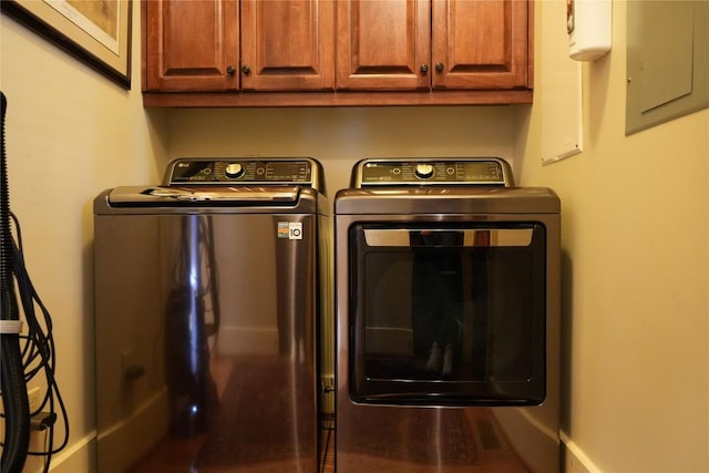 laundry area featuring washing machine and dryer, cabinet space, and electric panel