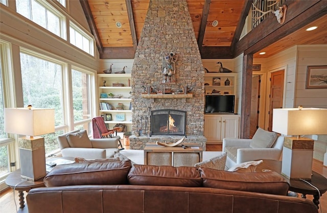 living room featuring wooden ceiling, wood finished floors, a stone fireplace, high vaulted ceiling, and beamed ceiling