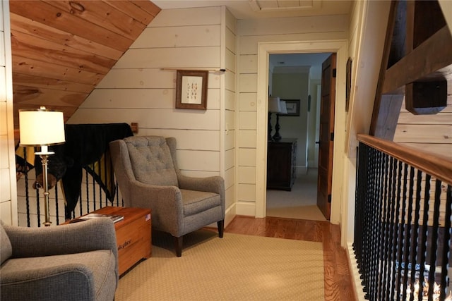 living area featuring wooden walls, wooden ceiling, and lofted ceiling