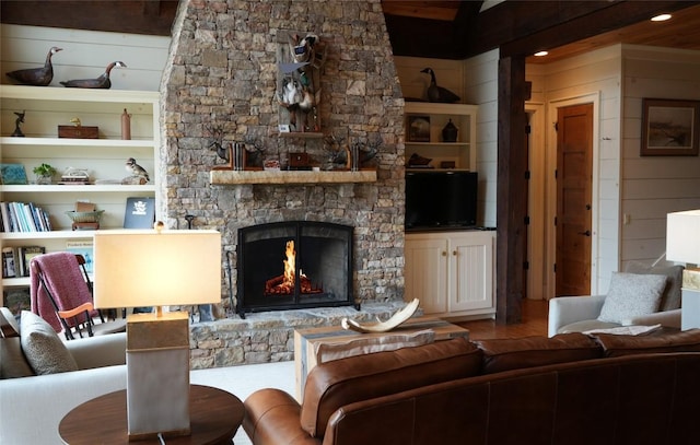 living room with wood walls, a fireplace, built in shelves, and wood finished floors