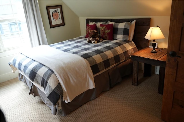 bedroom with carpet floors and vaulted ceiling