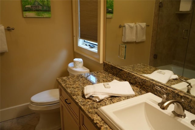 full bath with tile patterned floors, tiled shower, toilet, and vanity