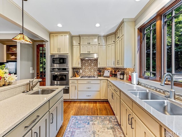 kitchen with sink, decorative light fixtures, backsplash, and appliances with stainless steel finishes