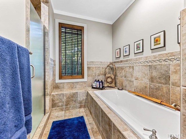 bathroom with ornamental molding and shower with separate bathtub