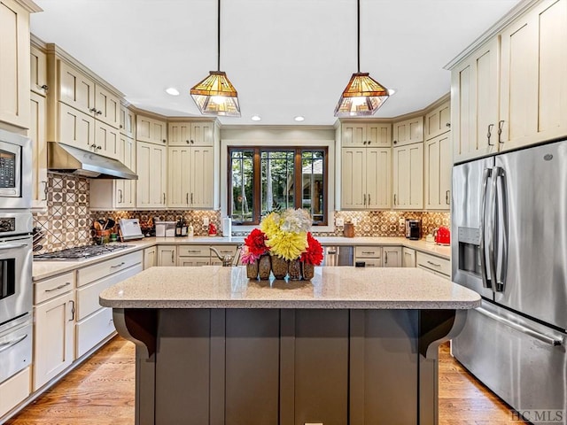 kitchen featuring a kitchen island, appliances with stainless steel finishes, and a kitchen bar