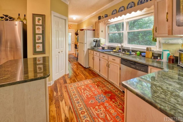 kitchen featuring dark wood-type flooring, light brown cabinetry, sink, a textured ceiling, and stainless steel appliances