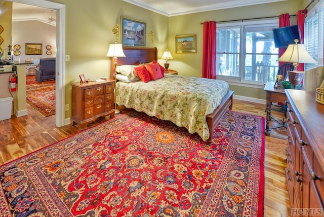 bedroom featuring crown molding and light hardwood / wood-style flooring