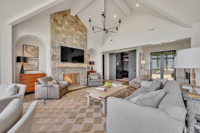 living room with beamed ceiling, a fireplace, and high vaulted ceiling