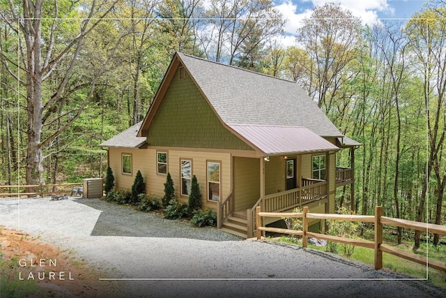 rustic home with a porch and a shingled roof