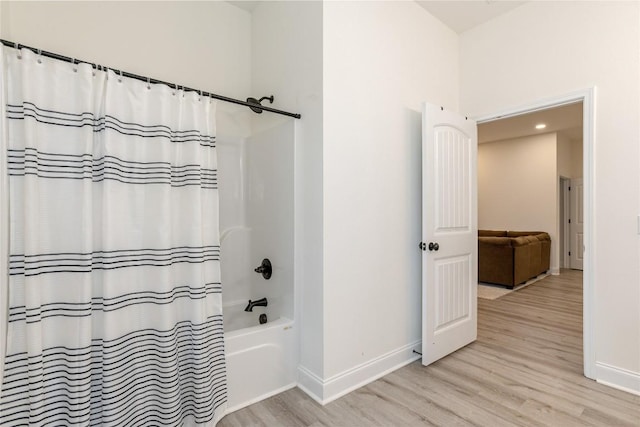 full bathroom with baseboards, wood finished floors, and shower / bath combo with shower curtain