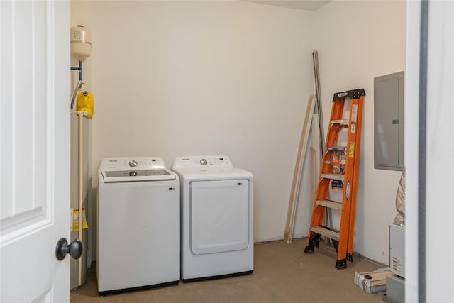 laundry room featuring electric panel, washing machine and clothes dryer, and light carpet