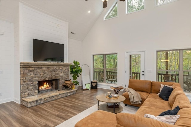 living room with high vaulted ceiling, wood finished floors, ceiling fan, a fireplace, and baseboards