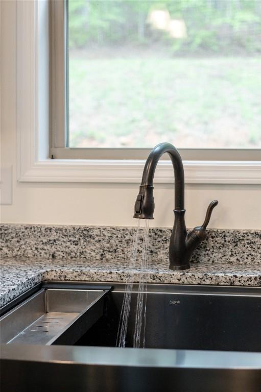 kitchen view of a sink and light stone countertops